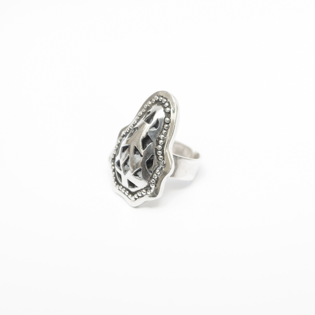 Silver ring with intricate design on a white background