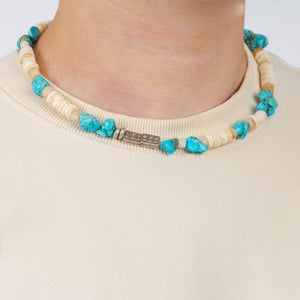 Necklace with turquoise and beige beads on a plain background