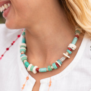 Colorful beaded necklace worn by a person with a blurred background
