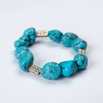 Turquoise beaded bracelet with silver accents on a white background