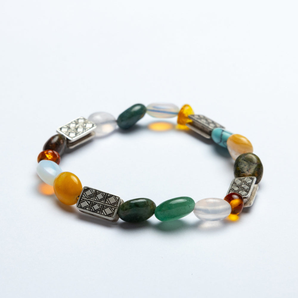Multicolored beaded bracelet with metallic accents on a white background