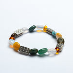 Multicolored beaded bracelet with metallic accents on a white background
