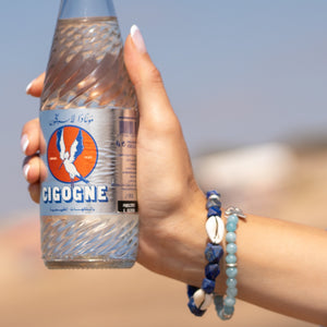 Hand holding a bottle of Cégéoé with a blurred background