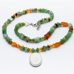 Necklace with multicolored beads and a silver pendant on a white background