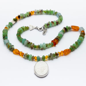 Necklace with multicolored beads and a silver pendant on a white background