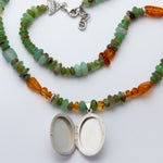 Necklace with multicolored beads and a silver locket on a white background